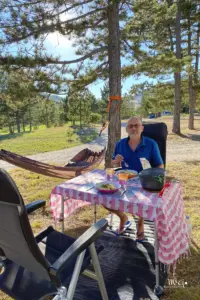 Ein Mann sitzt am gedeckten Tisch und ist bereit um zu essen.