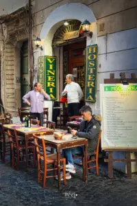 Kellner stehen vor dem Restaurant bereit für die Kundschaft und sind am diskutieren.