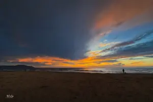 In diversen blau, gelb und orange tönen leuchtet der Abendhimmel über dem Meer.