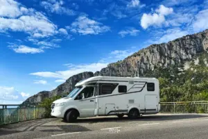 Wohnmobil steht am Strassenrand parkiert im Hintergrund das Bergmassiv.