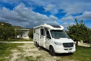 Wohnmobil auf einem Stellplatz parkiert inmitten von Zitronenbäumen