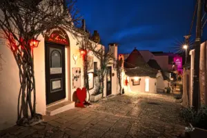 Nachtansicht in den Gassen von Alberobello vor einem beleuchteten Restaurant.