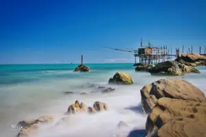 Ein Blick über die im Wasser liegenden Felsen führt zum Trabocco, dem Fischerhaus das auf Holzpfählen im Wasser steht.