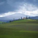 In der Weite der Toskana steht ein Haus einsam in der Landschaft.
