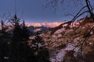 Die schneebedeckten Berggipfel vom Panorama leuchten am frühen morgen von der Sonne angestrahlt.