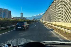 Sicht aus dem Cockpit eines Wohnmobils auf die Strecke voraus auf der Autobahn der Lärmschutzmauer entlang.