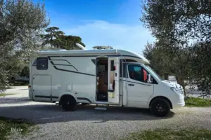 Wohnmobil parkiert zwischen Olivenbäumen in Alberobello.