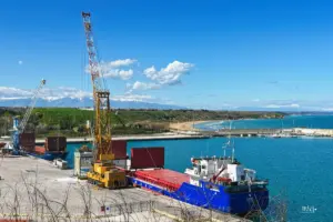 Das grosse Transportschiff wird im Hafen vom Ladekran entladen.