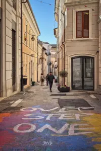 Die bunte Dekoration weist geradewegs in eine kleine Seitengasse in der Altstadt von L'Aquila.