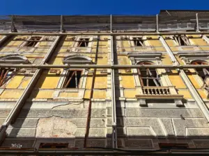 Ein vom Erdbeben von 2009 beschädigtes, unbewohnbares Haus in der Altstadt von L'Aquila wird von einem Stahlgerippe vor dem auseinander fallen gesichert.