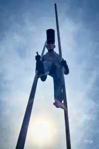 Eine Eisenskulptur zeigt einen Mann auf hohen Stelzen der über die Leute hinweg gehen könnte.